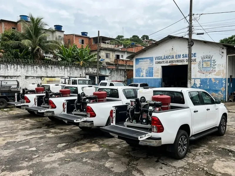Frota de picapes com UBV estacionada diante de um prédio público
